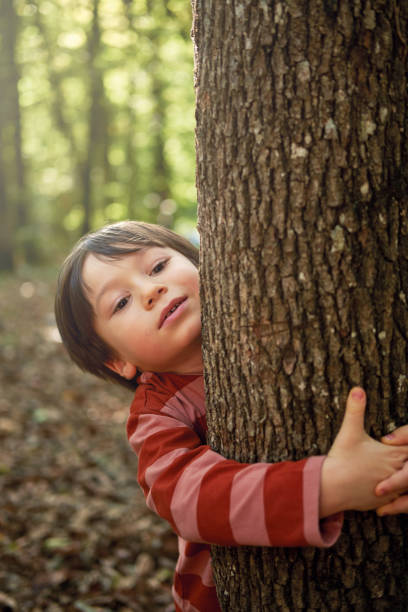 istock 4-5 years old cute child hugging tree and nature 1283039030