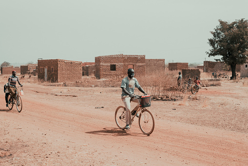 Burkina Faso is one of the poorest countries in the world. Its location south of the Sahara desert is the main cause of its arid climate and heavily affects the life of its inhabitants. The roads of Burkina are also in poor condition and the inhabitants take many hours to travel even a few kilometers. In this image, created for a reportage in December 2017, you can see a man and a woman on bicycles: this is the most common way, especially outside the capital Ouagadougou.