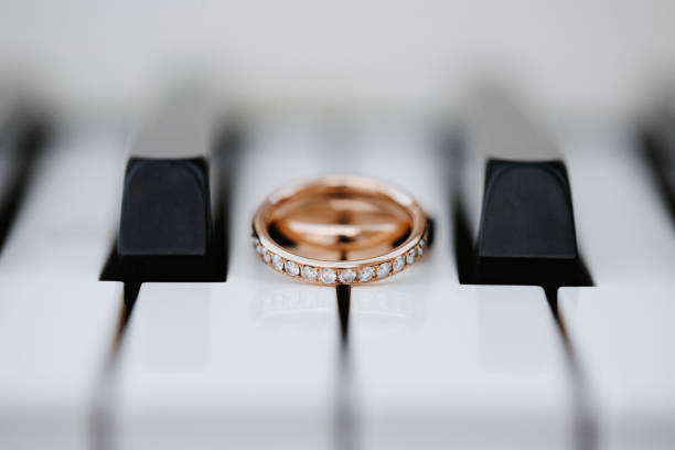 Wedding rings on piano keys with selective focus