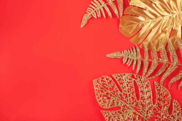 istock Golden leaves on bright red background. 1283045642
