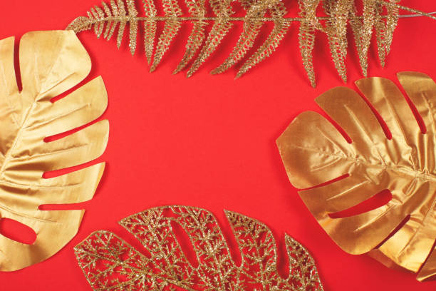 istock Golden leaves on bright red background. 1283045643