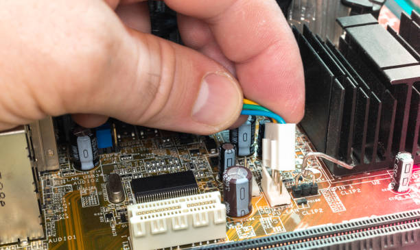 man installs a jumper from the cooler on the motherboard. Close-up stock photo