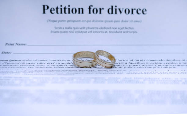 istock Blurred divorce contract papers with wedding jewelry. 1283046905