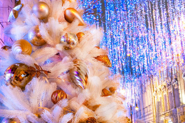 istock White christmas tree with yellow bauble and blue bokeh, copy space. Xmas decorations on new year 1283055268