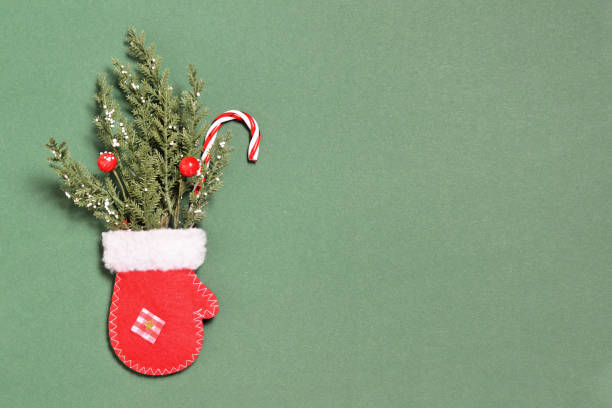 manopla de navidad roja y ramas de abeto sobre fondo verde con espacio de copia - felt white paper textile fotografías e imágenes de stock