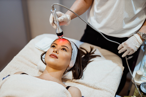 Young woman lying down in the beauty clinic and having an ultrasound cavitation treatment to remove cellulite and body fat
