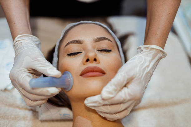 Woman having a facial cupping treatment in the beauty clinic Beautiful young woman lying down in the beauty clinic and having a facial cupping massage treatment to stimulate blood circulation hands cupped stock pictures, royalty-free photos & images