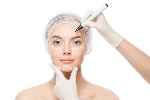 young woman, beauty clinic patient, ready for face lifting procedures, doctor in gloves uses skin marker, isolated on white background - rebellion aging process facial mask beauty treatment imagens e fotografias de stock