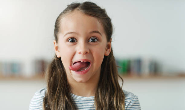 She's always in the mood to play Cropped shot of a little girl making silly faces tongue stock pictures, royalty-free photos & images