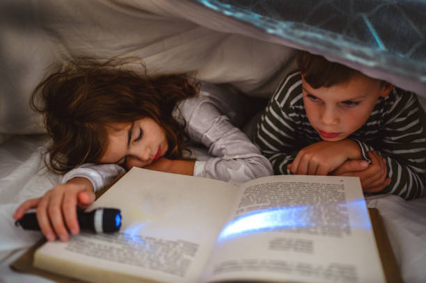 istock Children reading in the book under the blanket 1283062995