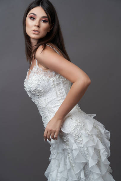 istock Beautiful bride in wedding dress posing on grey background 1283063927