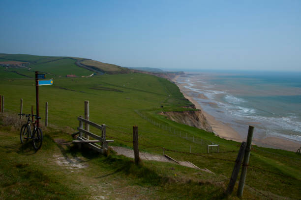 scenic coastal view of isle of wight featuring the ocean, a narrow beach on the foothills of cliffs. - barbed wire rural scene wooden post fence imagens e fotografias de stock