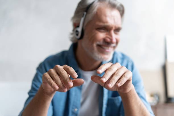istock Head shot man sit on sofa in living room makes video call looks at camera, conversation by distant videocall 1283064165
