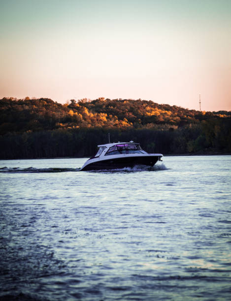 Large boat on the St Croix River during a sunset with orange trees in the background.