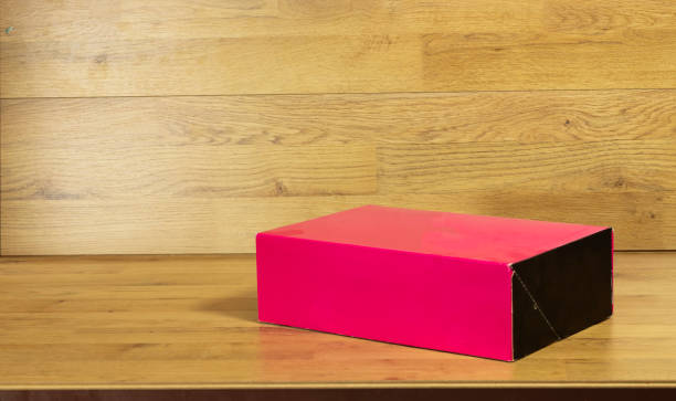 istock Closed red package box  on wood table , blank advertise template for products packaging. 1283065505