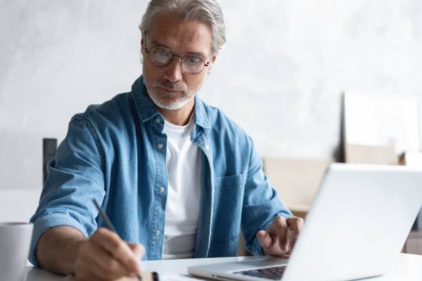 istock Middle-aged man working from home-office on laptop. 1283065768