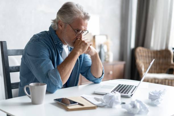istock Stressed tired freelancer having headache and thinking how to finish his work, sitting and suffering at his home office 1283065791