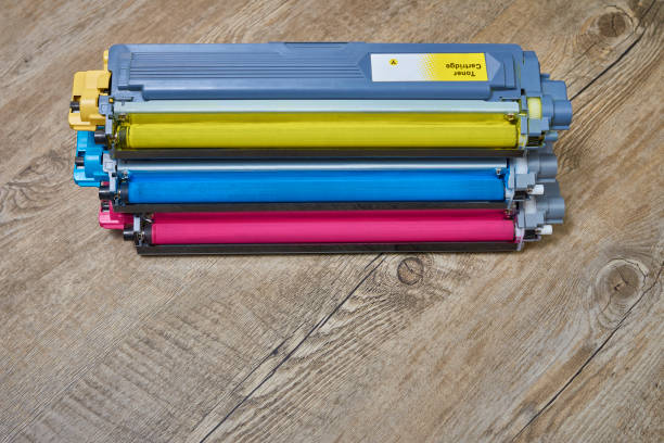 istock Three toner cartridges for color laser printer stacked on wooden table 1283069602