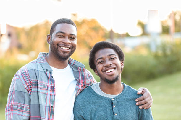 istock Proud dad has arm around smiling son 1283072028