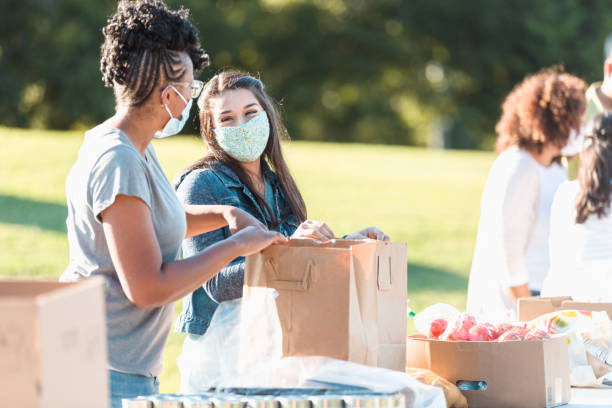 istock Friends smile and talk while volunteering at food drive 1283072040