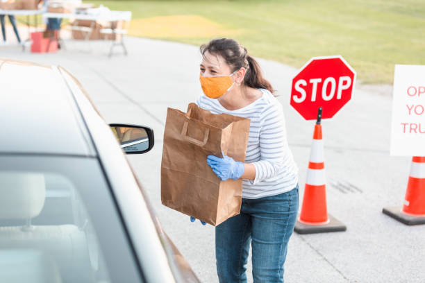 istock Woman wears protective mask while volunteering during food drive 1283072144