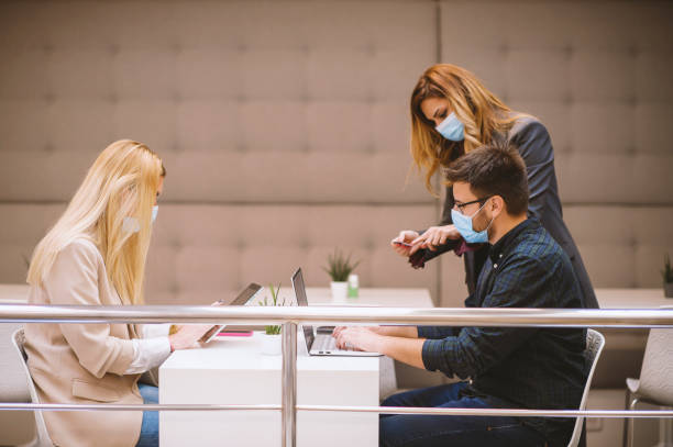 istock Business colleagues working together in a conference office, making a business plan wearing protective face masks during a coronavirus, covid-19 pandemic. 1283075593