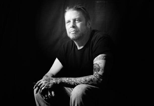 istock Man With Tattoos Smoking a Cigarette Black and White 1283076215