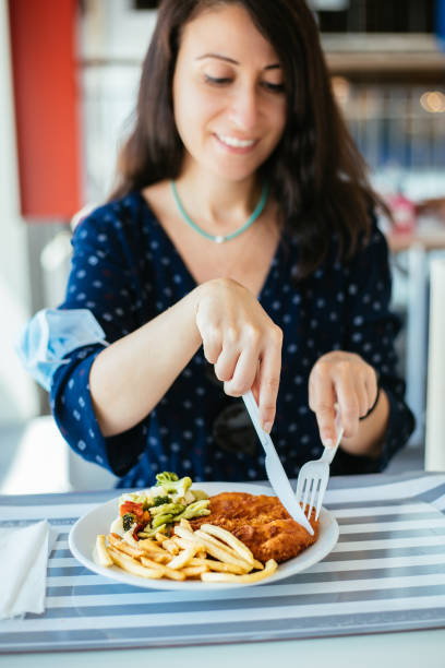 istock Woman with protective face mask holding serving tray, having lunch at cafeteria 1283077633