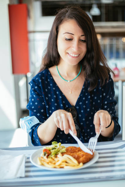 istock Woman with protective face mask holding serving tray, having lunch at cafeteria 1283077689