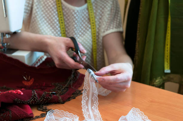 istock tailor cutting white lace with scissors on wooden table 1283078530