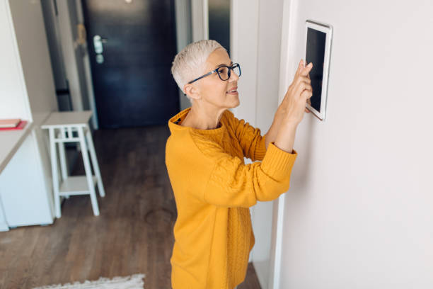 istock Mature woman adjusting a smart system at her house 1283079418