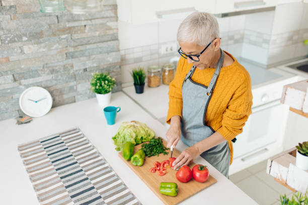 istock Senior woman preparing vegetarian dinner at her kitchen 1283079652
