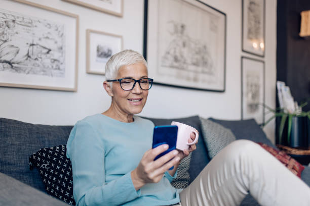 istock Happy senior woman enjoying coffee and using smartphone 1283080523