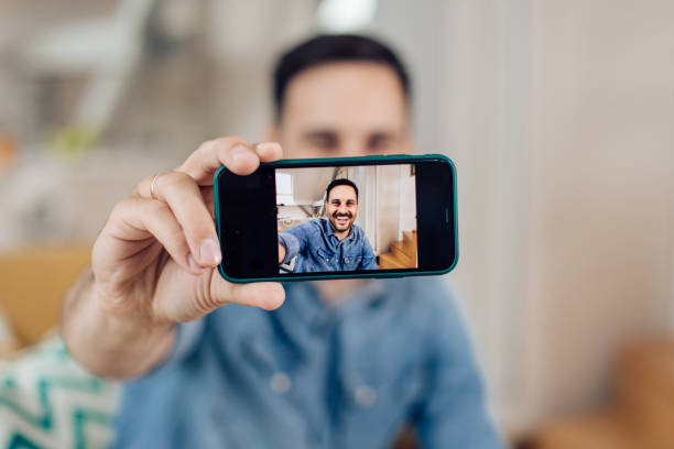 istock Young man taking a selfie at home 1283080758