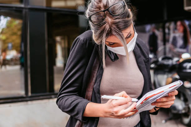 istock Woman talking on phone taking notes outdoors 1283082514