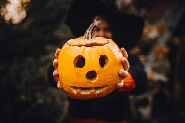 istock Smiling Woman Holding Jack o' Lantern 1283087579