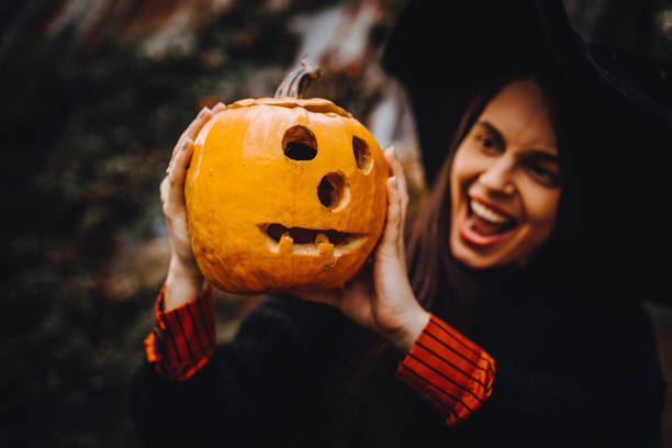 istock Smiling Woman Holding Jack o' Lantern 1283088424