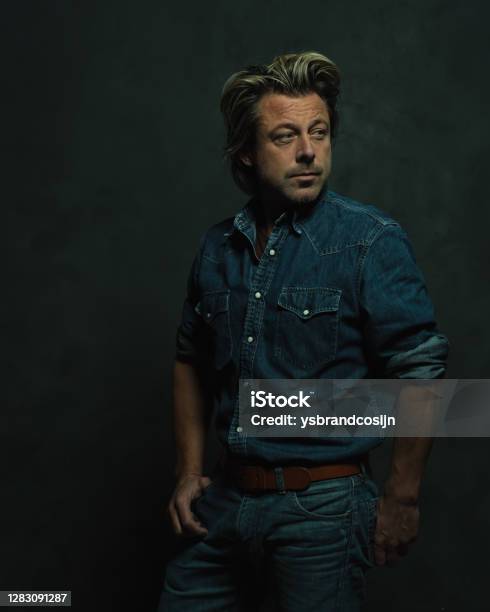 Atmospheric Dark Studio Portrait Of A Tough Middleaged Man With Blonde Hair In A Jeans Shirt Stock Photo - Download Image Now - iStock Atmospheric Dark Studio Portrait Of A Tough Middleaged Man With Blonde Hair In A Jeans Shirt Stock Photo - Download Image Now - iStock