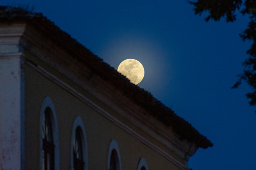 Full moon with old building in background