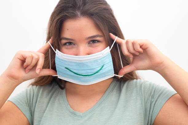 istock Young woman holding a surgical mask with a smile draw 1283095886