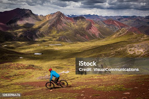 istock Mountain bikers riding by llamas in foothills of Peruvian Andes. 1283096476