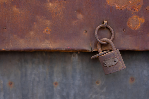 Close-up of a lock with a chain that closes a metal gate during the day