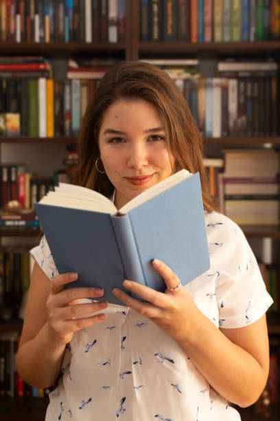 istock Young woman holding book in her hands 1283096589