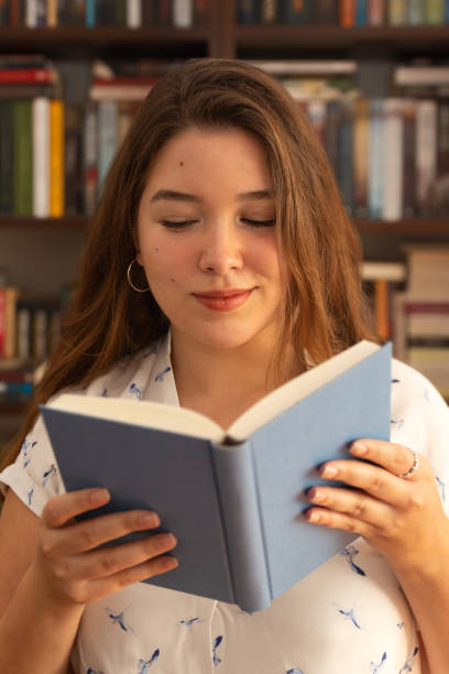 istock Young woman holding book in her hands 1283096598