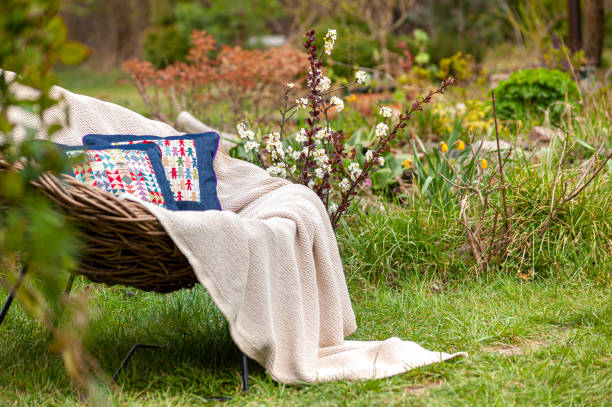 istock Soft luxury home textile set on whicker chair in beautiful garden 1283097552