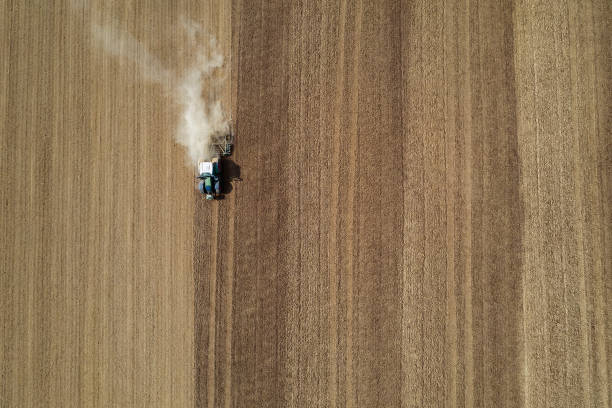 istock Tractor with harrow on field from above 1283098147