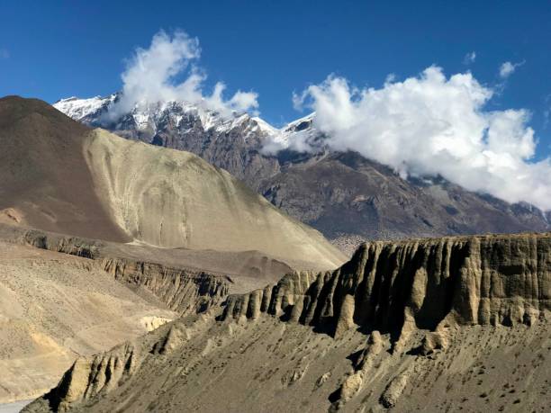 Spectacular view on Himalayan mountain landscape in Mustang Kingdom, Nepal, awesome rock cliff with ancient man made human cave dwellings, beautiful cloudscapein heaven over Himalayas.  Vast wilderness, meditation, calmness, spirituality, solitude.. Mustang district, Nepal, Asia, spring season. annapurna circuit photos stock pictures, royalty-free photos & images