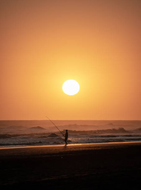 istock Fishing at the beach with a sunset 1283107570