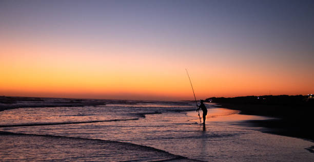 istock Fishing at the beach with a sunset 1283107573
