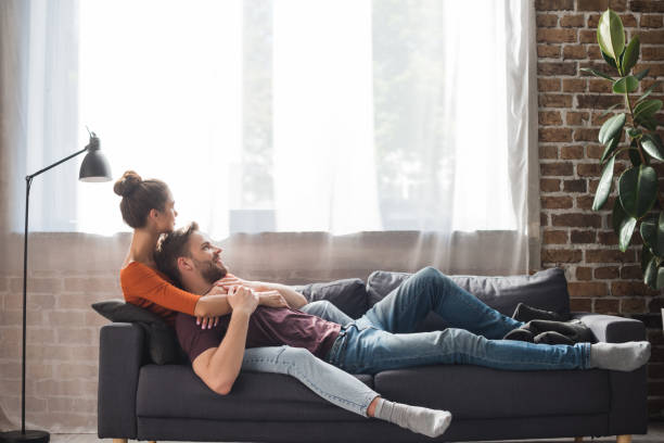 istock young couple relaxing on sofa near window at home 1283109228